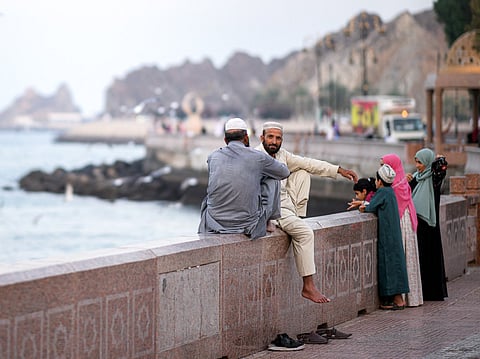 Two men sit along the corniche in Oman's capital Muscat on February 5, 2026.