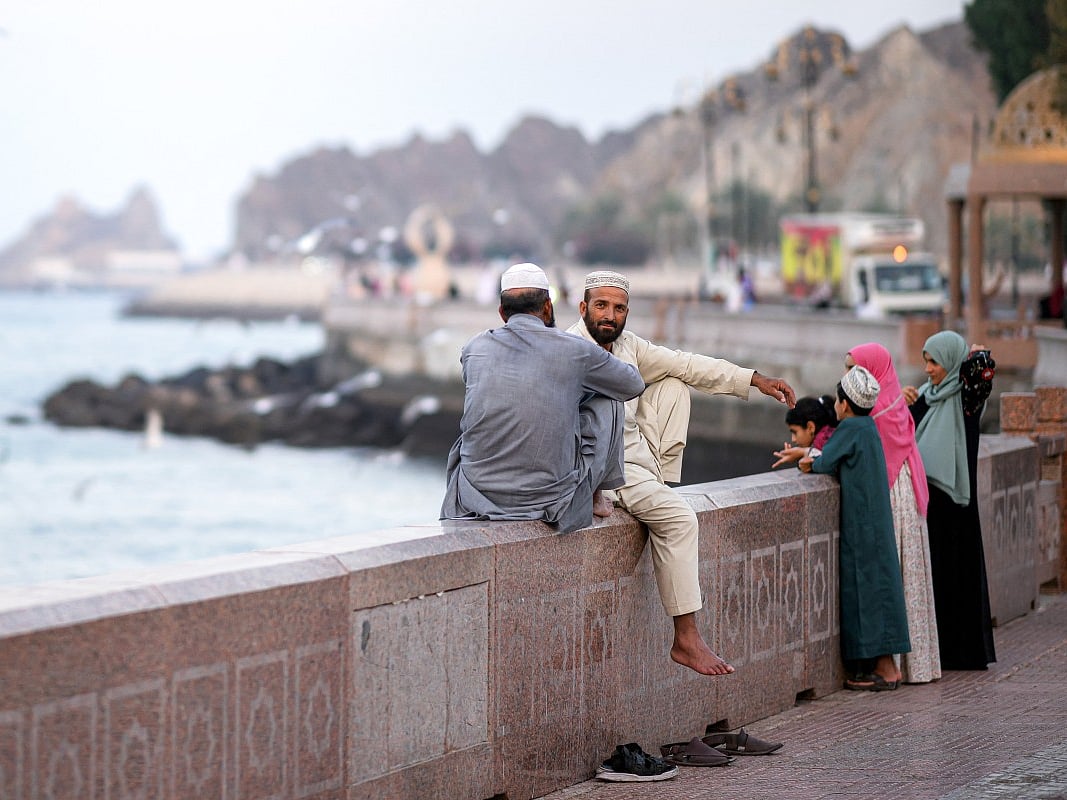 Two men sit along the corniche in Oman's capital Muscat on February 5, 2026.