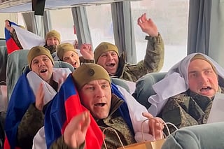 Russian servicemen with Russian national flags react in a bus after returning from captivity during a POWs exchange of a group of servicemen between Russia and Ukraine at an undisclosed location in Belarus, on Thursday, February 5, 2026..  