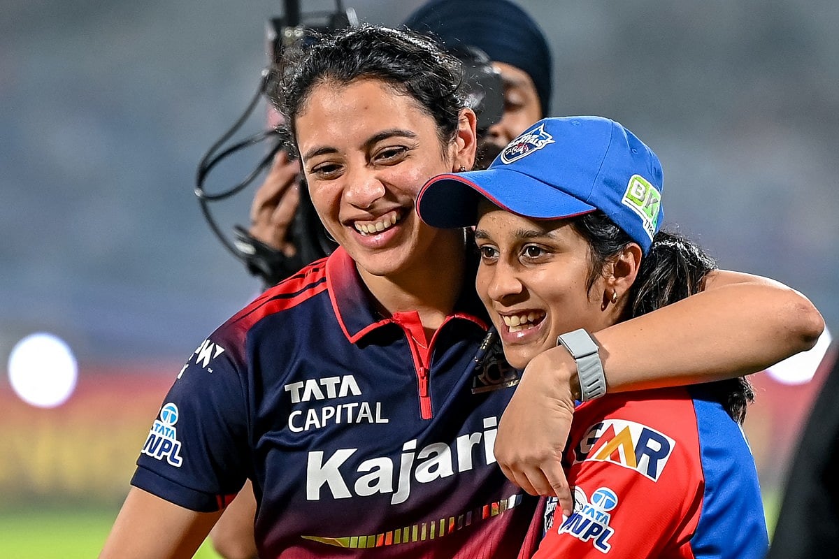 Royal Challengers Bengaluru's captain Smriti Mandhana and her Delhi Capitals' counterpart Jemimah Rodrigues share a light moment at the end of the Women's Premier League (WPL) Twenty20 final match at the Kotambi Stadium in Vadodara on February 5, 2026.
