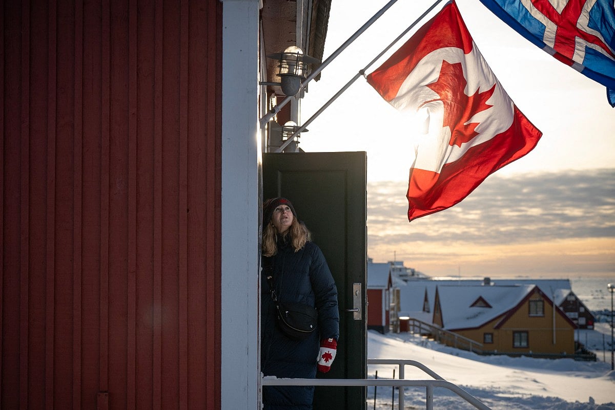 A member of the Canadian delegation looks at her country’s flag flying above the new Canadian consulate before its opening, in Nuuk, Greenland on February 6, 2026.
