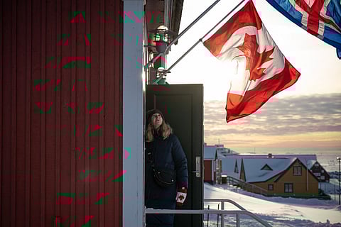 A member of the Canadian delegation looks at her country’s flag flying above the new Canadian consulate before its opening, in Nuuk, Greenland on February 6, 2026.