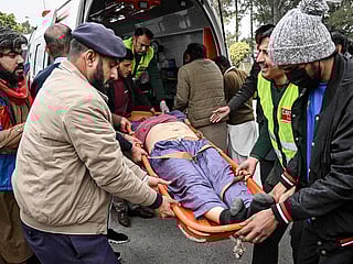 People shift an injured man to a hospital following an explosion at a mosque in Islamabad on February 6, 2026. 