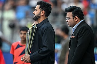 India's cricketer Rohit Sharma (L) holds the 2026 ICC Men's T20 Cricket World Cup trophy as Jay Shah, chairman of International Cricket Council (ICC), looks on during a ceremony before the start of the group stage match between India and USA at the Wankhede Stadium in Mumbai on February 7, 2026.