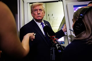 President Donald Trump gaggles with reporters while aboard Air Force One on February 6, 2026 en route to Palm Beach, Florida.