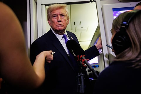 President Donald Trump gaggles with reporters while aboard Air Force One on February 6, 2026 en route to Palm Beach, Florida.