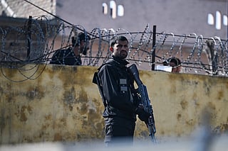 A security personnel stands guard near the site of funeral ceremony held for suicide blast victims, a day after the attack at a mosque in Islamabad on February 7, 2026.
