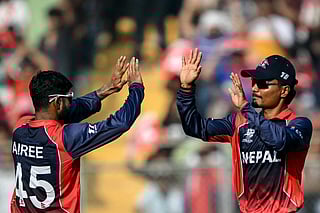 Nepal's Dipendra Singh Airee (L) celebrates with captain Rohit Paudel after taking the wicket of England's Sam Curran during the 2026 ICC Men's T20 Cricket World Cup group stage match between England and Nepal at the Wankhede Stadium in Mumbai on February 8, 2026.