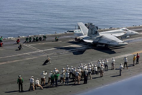A handout photograph released by the US Navy on February 8, 2026, shows observers including US lead negotiators Steve Witkoff and Jared Kushner, as they watch flight operations on the flight deck of Nimitz-class aircraft carrier USS Abraham Lincoln (CVN 72) in the Arabian Sea, on February 7, 2026.