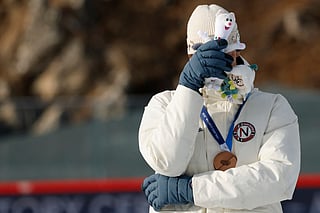 Bronze medallist Norway's Sturla Holm Laegreid reacts on the podium of the men's biathlon 20km individual event during the Milano Cortina 2026 Winter Olympic Games 