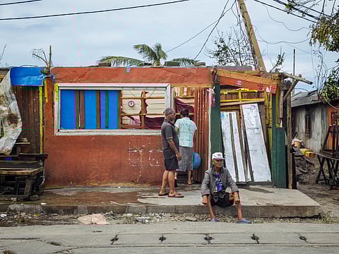 Residents gather near a destroyed house in the city of Toamasina, on the east coast of Madagascar, struck by Tropical Cyclone Gezani on February 11, 2026. At least 38 people were killed, 18,000 homes destroyed.