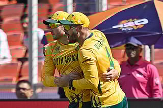South Africa's David Miller (L) celebrates with captain Aiden Markram after taking a catch to dismiss Afghanistan's captain Rashid Khan during the 2026 ICC Men's T20 Cricket World Cup group stage match between Afghanistan and South Africa at the Narendra Modi Stadium in Ahmedabad on February 11, 2026.