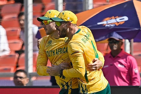 South Africa's David Miller (L) celebrates with captain Aiden Markram after taking a catch to dismiss Afghanistan's captain Rashid Khan during the 2026 ICC Men's T20 Cricket World Cup group stage match between Afghanistan and South Africa at the Narendra Modi Stadium in Ahmedabad on February 11, 2026.