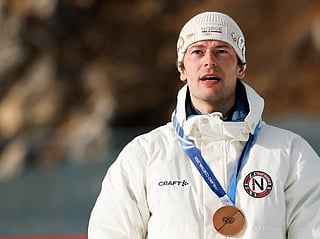 Bronze medallist Norway's Sturla Holm Laegreid poses on the podium of the men's biathlon 20km individual event during the Milano Cortina 2026 Winter Olympic Games