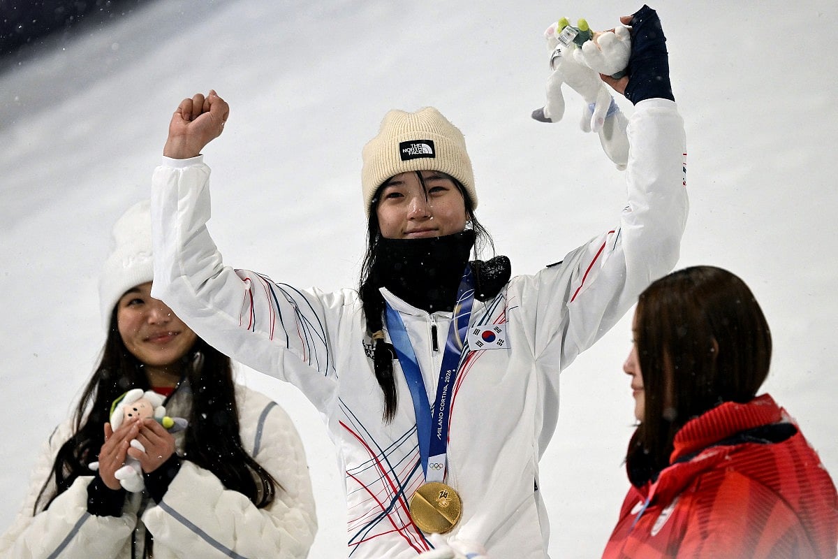 Silver medallist USA's Chloe Kim, gold medallist South Korea's Choi Gaon and bronze medallist Japan's Mitsuki Ono celebrate on the podium after the snowboard women's halfpipe final during the Milano Cortina 2026 Winter Olympic Games at Livigno Snow Park, in Livigno (Valtellina), on February 12, 2026.