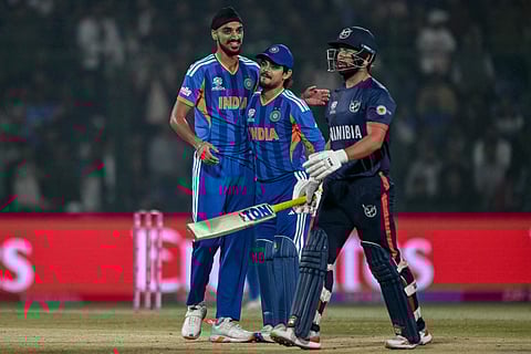 India's Arshdeep Singh (L) celebrates with wicketkeeper Ishan Kishan (C) after taking the wicket of Namibia's Jan Frylinck during the 2026 ICC Men's T20 Cricket World Cup group stage match between India and Namibia at the Arun Jaitley Stadium in New Delhi on February 12, 2026.