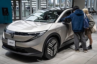 People look at a car on display at a showroom of Japanese automaker Nissan Motor in Yokohama, Kanagawa prefecture on February 11, 2026.