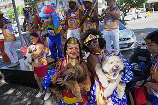 Owners and their pets pose for a photo at the "Blocao" Carnival dog parade in Rio de Janeiro, Saturday, Feb. 14, 2026. 