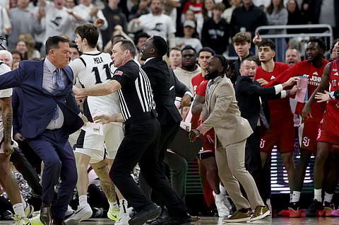 A game official separates St. John's coaches and players after a fight broke out during the second half of an NCAA college basketball game against Providence, Saturday, Feb. 14, 2026, in Providence, Rhode Island.