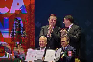 Canada's Minister of Internal Trade, Dominic LeBlanc (top-L) and Mexico's Secretary of Economy, Marcelo Ebrard (top-R), applaud after the signing of a memorandum of understanding during a meeting with Canadian business leaders in Mexico City on February 16, 2026.