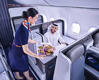 A flydubai cabin crew serves a passenger onboard its Business Class cabin. The carrier confirmed it will begin twice-daily services to Bangkok from September, expanding its footprint in Southeast Asia.