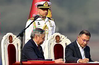 Bangladesh's newly sworn-in Prime minister Tarique Rahman (R) signs after taking oath during a swearing-in ceremony at the National Parliament building in Dhaka on February 17, 2026.