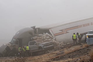 Emergency personnel work the scene of a crash involving 30-plus vehicles including six semi trucks on Interstate 25 south of Pueblo, Colo., on Tuesday, Feb. 17, 2026.  