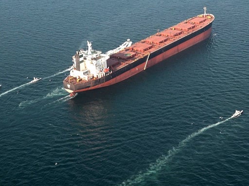 A container vessel transits the Strait of Hormuz, a critical global trade and energy corridor, as tensions in the Gulf disrupt shipping and drive oil prices higher.