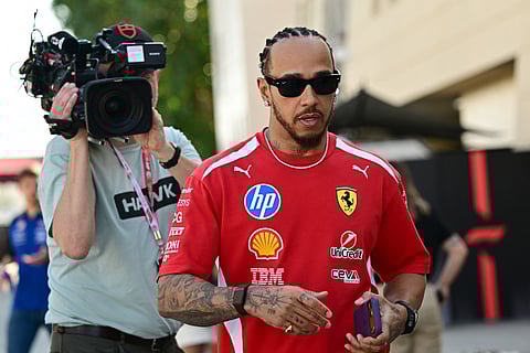 Ferrari's British driver Lewis Hamilton walks in the paddock on the first day of the second Formula One pre-season test at the Bahrain International Circuit in Sakhir on February 18, 2026.