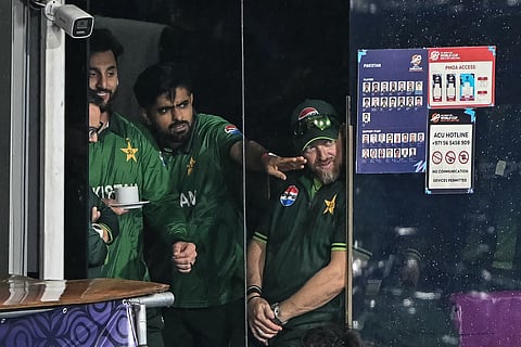 Pakistan's Babar Azam (C) and his captain Salman Agha (L) react after the 2026 ICC Men's T20 Cricket World Cup Super Eight match between Pakistan and New Zealand was called off due to rain at the R Premadasa Stadium in Colombo on February 21, 2026.