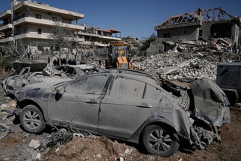 People gather near a building destroyed in an Israeli strike in the village of Bednayel in eastern Lebanon, Saturday, Feb. 21, 2026. (AP Photo/Bilal Hussein)
