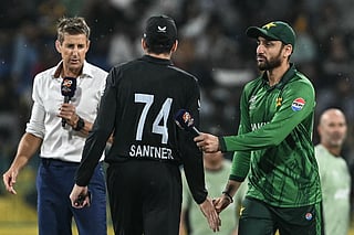 Pakistan's captain Salman Agha (R) shakes hands with New Zealand's captain Mitchell Santner (C) during the toss before the start of the 2026 ICC Men's T20 Cricket World Cup Super Eight match between Pakistan and New Zealand at the R Premadasa Stadium in Colombo on February 21, 2026.