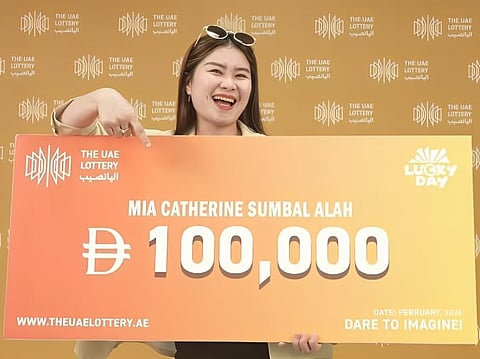 A life-changing first try: Mia Catherine Sumbal Alah proudly displays her Dh100,000 winnings from the UAE Lottery draw.