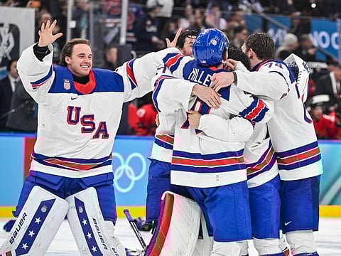 USA players celebrate winning the men's gold medal ice hockey match between Canada and USA at the Milano Santagiulia Ice Hockey Arena 