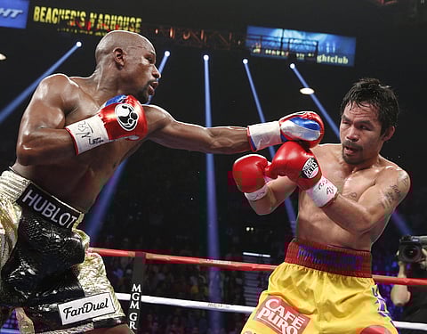 Floyd Mayweather Jr. exchange punches with Manny Pacquiao during their welterweight unification championship bout, May 2, 2015 at MGM Grand Garden Arena in Las Vegas, Nevada.