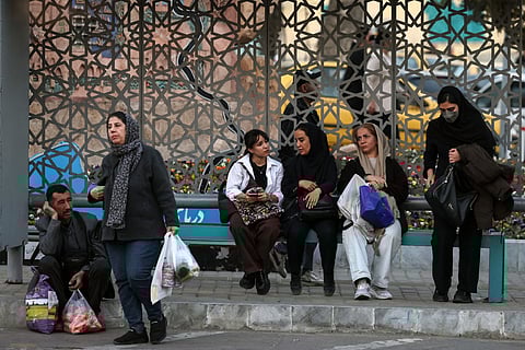 Iranians wait at a bus station in northern Tehran on February 23, 2026.