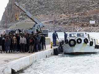 Migrants disembark from a boat at the port of Kali Limenes, in Heraklion, southern Crete.
