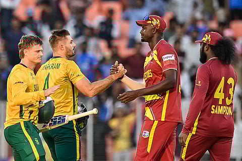 South Africa's captain Aiden Markram (2L) and his teammate Ryan Rickelton (L) shake hands with West Indies' Jason Holder (2R) and Quentin Sampson at end of the 2026 ICC Men's T20 Cricket World Cup Super Eights match between West Indies and South Africa at Narendra Modi Stadium in Ahmedabad on February 26, 2026.