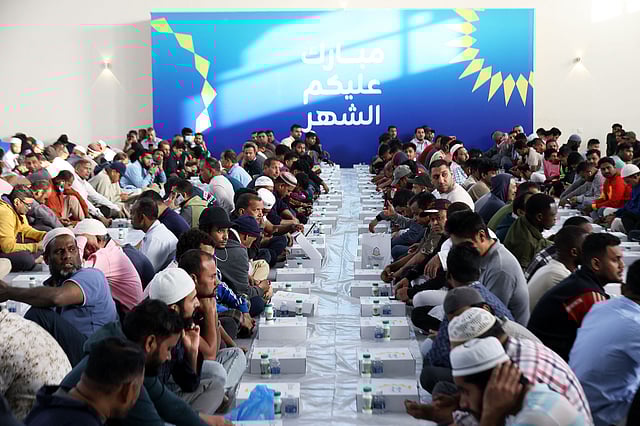 Workers gather and wait to break their fast during Ramadan inside a hall in Kuwait City.