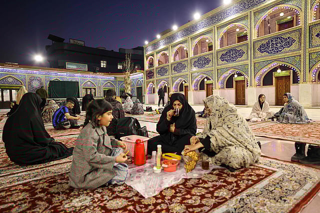 An Iranian family breaks their Ramadan fast at iftar in the grounds of Imamzadeh Saleh Mosque in Tehran.