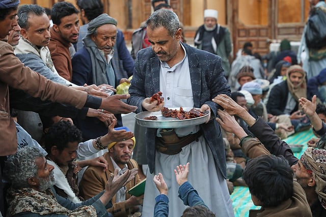 A volunteer distributes free food at the Grand Mosque, in Sanaa, Yemen.