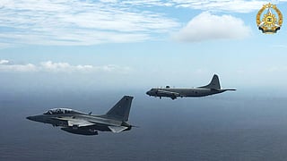 This handout photo taken on February 26, 2026 and released on February 27 by the Armed Forces of the Philippines-Public Affairs Office (AFP-PAO) shows a Philippine air force FA-50 fighter jet (L) flying alongside a Japan Maritime Self-Defence Force's P-3 Orion maritime patrol aircraft during a joint military exercise in the disputed South China Sea.