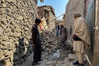 Residents stand near a damaged house following the overnight cross-border fighting between Pakistan and Afghanistan in Bajaur, Khyber Pakhtunkhwa province, on February 27, 2026.
