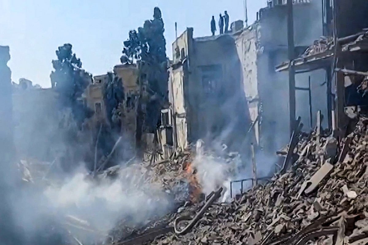 This video grab taken from UGC images posted on social media on February 28, 2026 and verified by AFPTV teams in Paris shows people inspecting the damage at an impact site following US and Israeli strikes on Tehran.