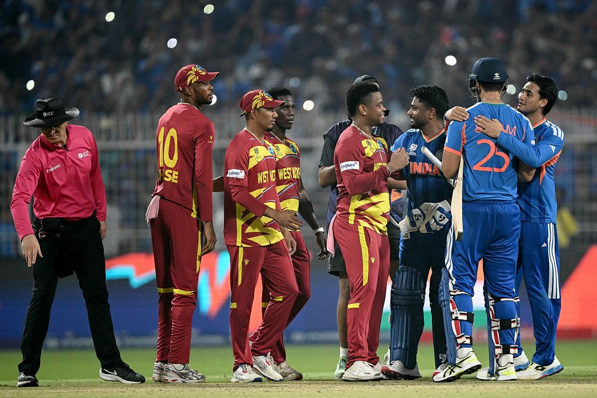 Umpire Alex Wharf gestures as West Indies' Roston Chase, Gudakesh Motie, Shamar Joseph and Shimron Hetmyer congratulate India's Sanju Samson, Shivam Dube and Abhishek Sharma for their team's win at the end of their 2026 ICC Men's T20 Cricket World Cup Super Eights match in the Eden Gardens, Kolkata on March 1, 2026.