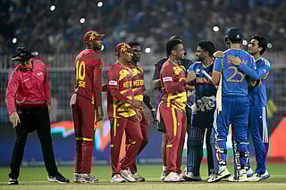 Umpire Alex Wharf gestures as West Indies' Roston Chase, Gudakesh Motie, Shamar Joseph and Shimron Hetmyer congratulate India's Sanju Samson, Shivam Dube and Abhishek Sharma for their team's win at the end of their 2026 ICC Men's T20 Cricket World Cup Super Eights match in the Eden Gardens, Kolkata on March 1, 2026.