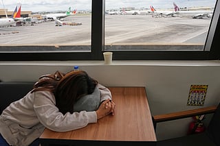 An overseas Filipino worker sleeps as she waits for updates on her cancelled flight to the Middle East at Manila's International Airport, Philippines