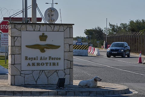 A dog sits at the main gate of the U.K.’s RAF Akrotiri air base after it was hit by a drone strike early morning near Limassol, Cyprus, Monday, March, 2, 2026. 