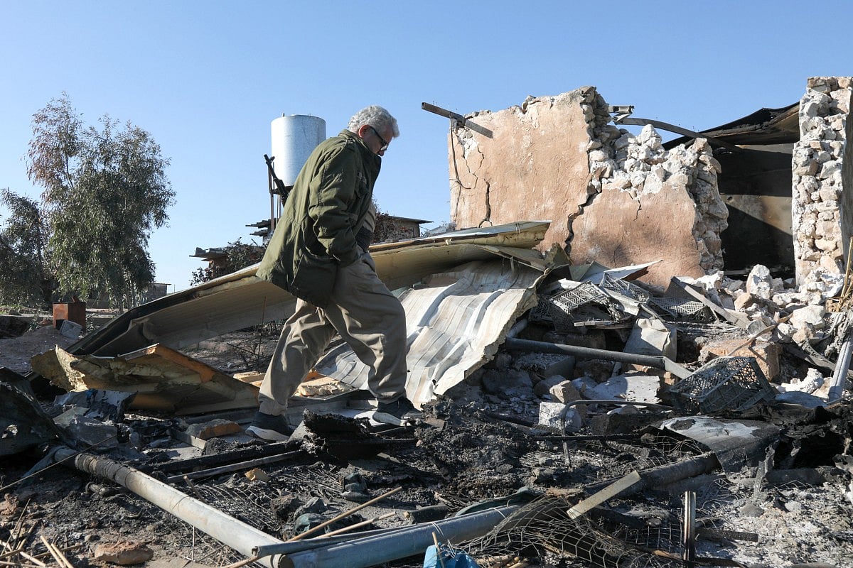 An Iranian inspects the damage sustained following an Iranian cross-border attack.