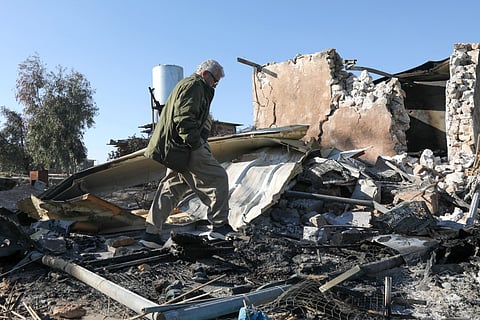 An Iranian inspects the damage sustained following an Iranian cross-border attack.